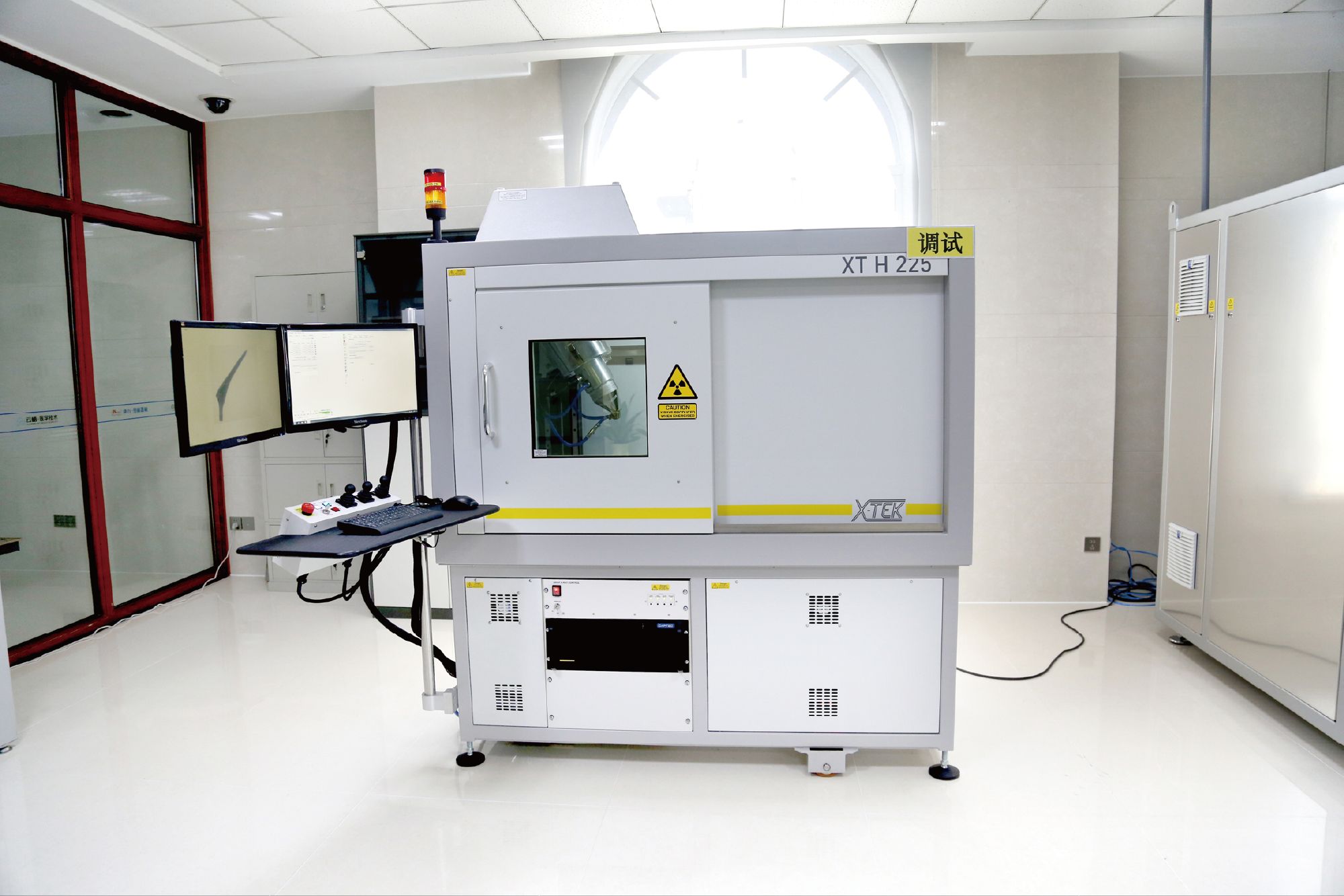 X-Tek XT H 225 industrial CT scanner with twin operator monitors showing a scanned implant cross-section