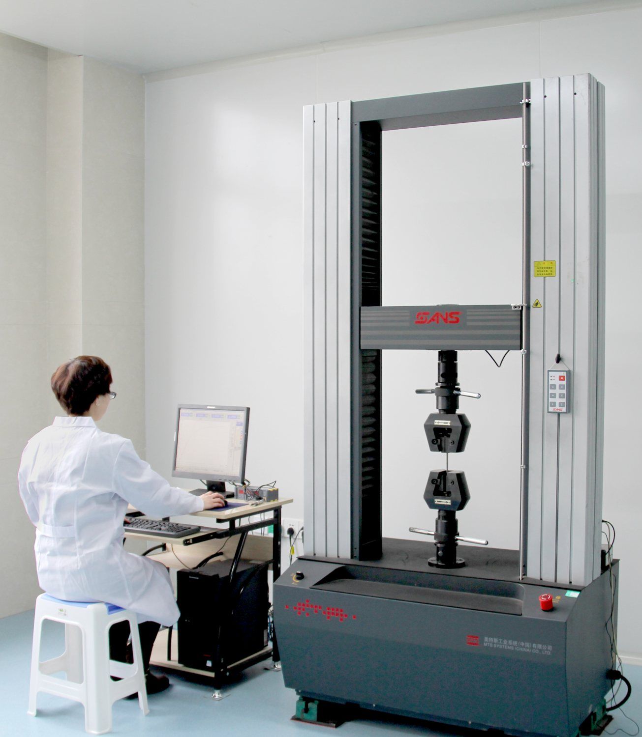 Kangli engineer running a tensile test on a computer-controlled electronic universal testing machine