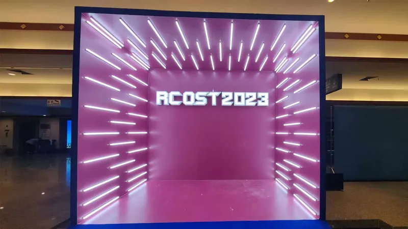 One empty rectangular walk-in installation with a navy frame, magenta walls and floor, and repeated white LED bars in a polished event hall.