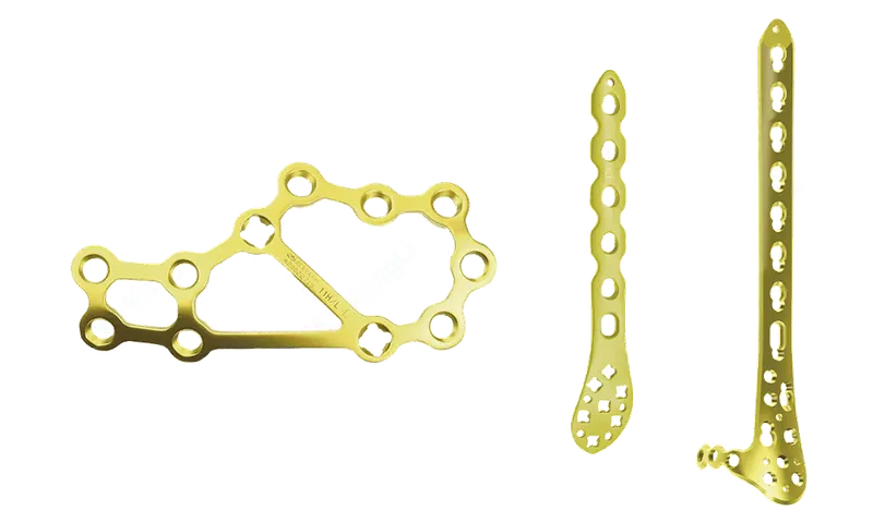 Four gold-coloured perforated plates arranged against a black background, including an irregular plate and an open ring-shaped plate.