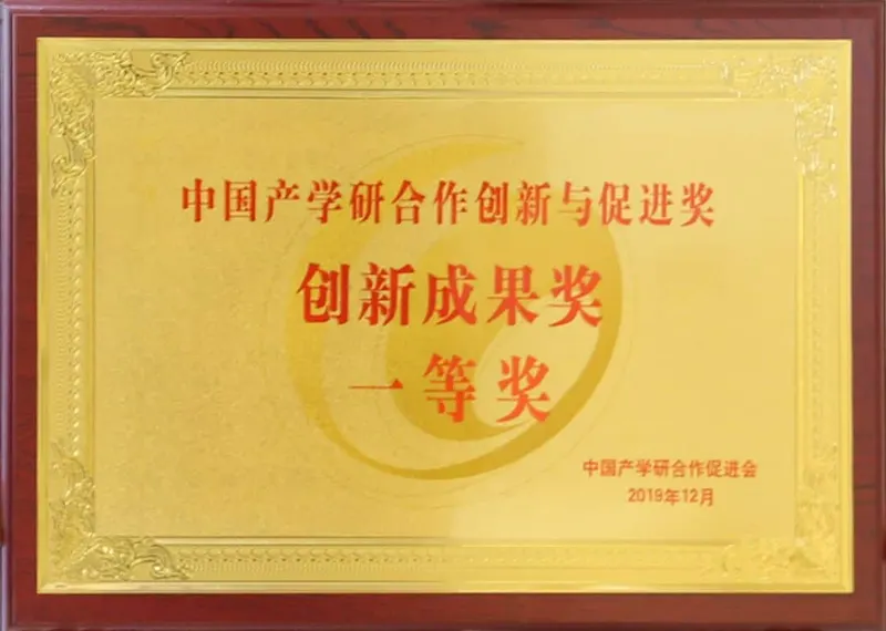 A framed gold-toned award plaque with red lettering and ornamental borders fills a close-up against a narrow reddish-brown frame.