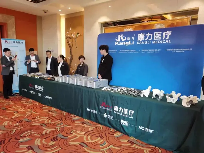 Six people stand behind or beside a long table with arranged trays of components, and a seventh person is cropped at the right edge beneath a branded backdrop.