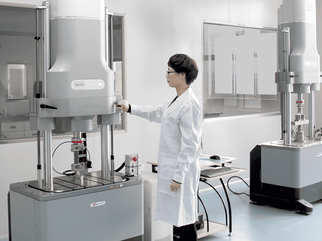 A female test operator standing confidently in front of the test equipment on the test platform.